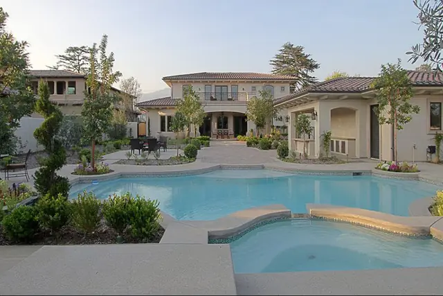 Pool and spa courtyard at dusk behind a Chateau estate